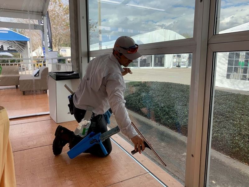 Technician squeegeeing a glass wall panel